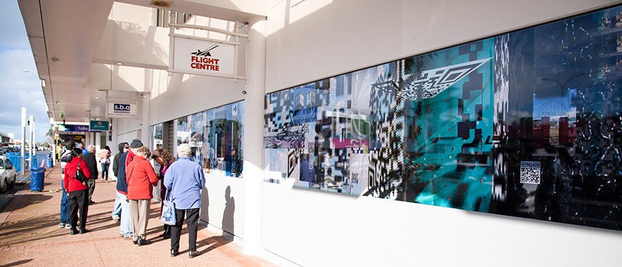 People standing on street outside shopping mall.