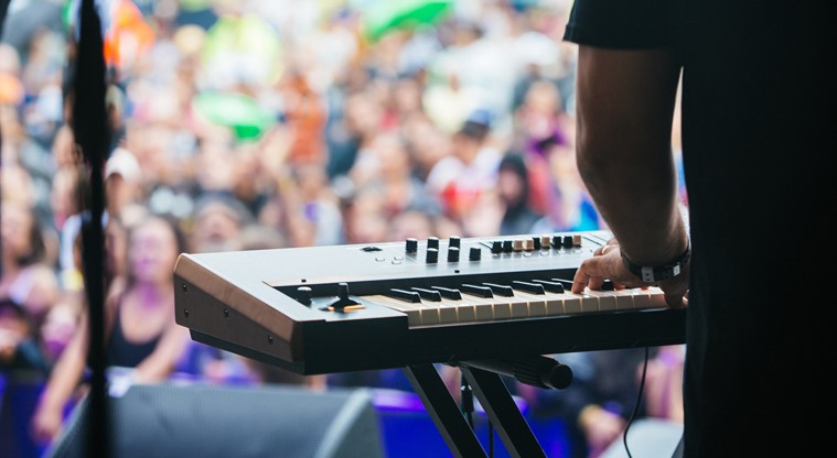 A pianist playing the keyboard before the crowd at a Music in Parks event. 