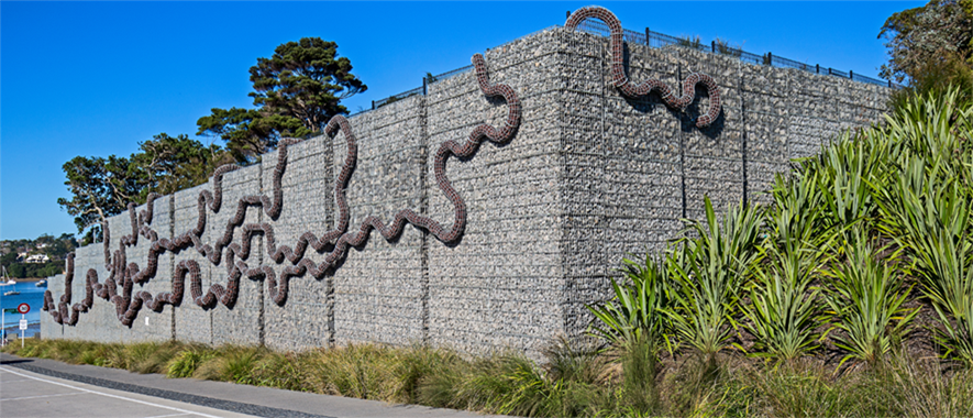 A concret wall with snake-like pattern on it.