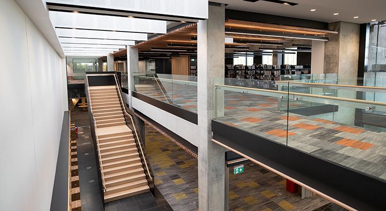 A mezzanine with a staircase leading to an upper library floor.