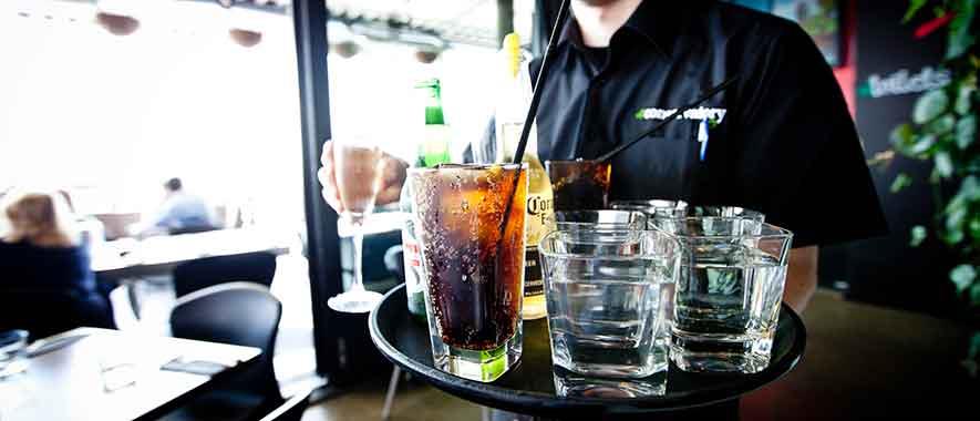 Waiter carrying a tray of drinks. 