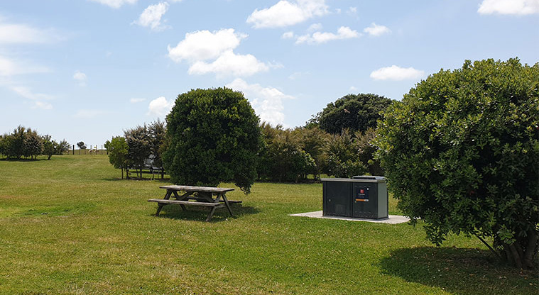 Ambury Campground - Barbecue and picnic table in the camping area.
