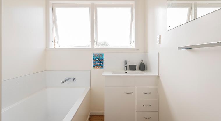 Kaipātiki Bach - Bathroom showing the vanity and bath.