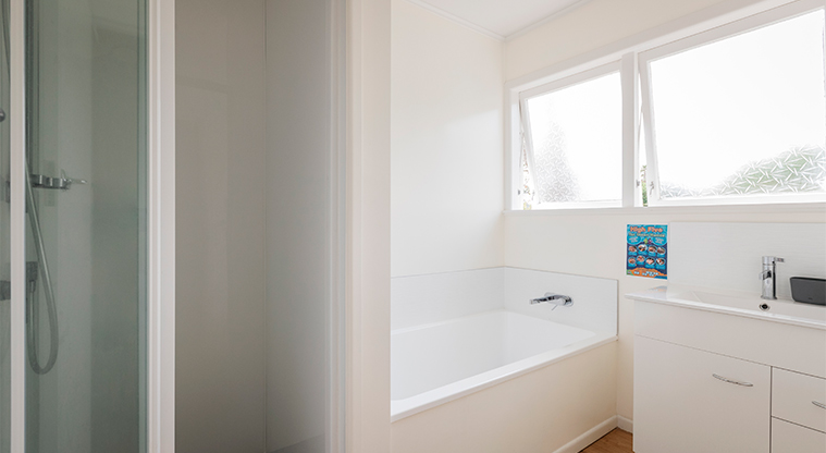 Kaipātiki Bach - Bathroom showing the vanity, bath and shower.