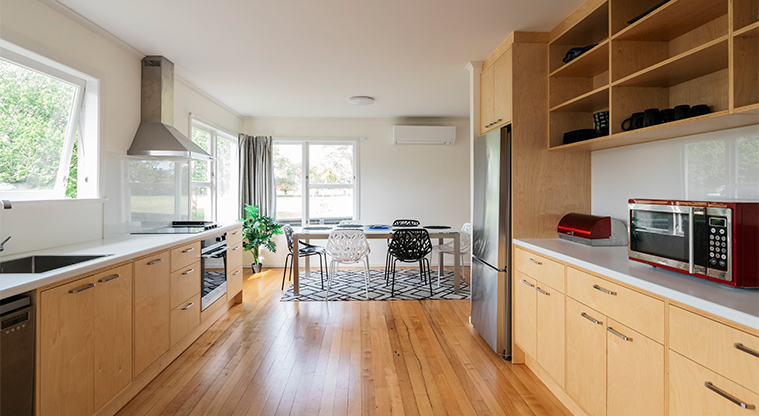 Kaipātiki Bach - Whole kitchen with the dining area in the background.