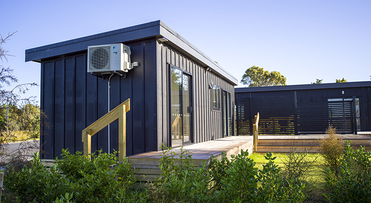 Te Kopua tiny home - Heatpump on the outside wall of the tiny home and the back deck.