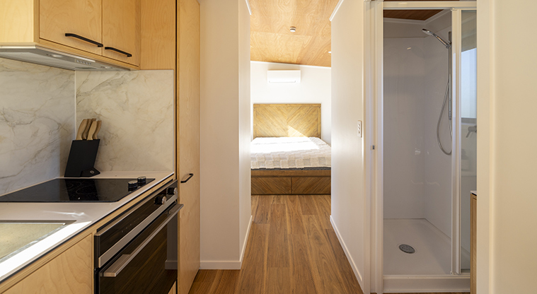 Te Kopua tiny home - Kitchen on the left, bathroom on the right and the bedroom in the background.