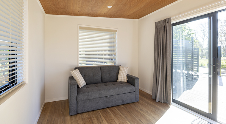 Te Kopua tiny home - Couch / fold out bed in the living area.