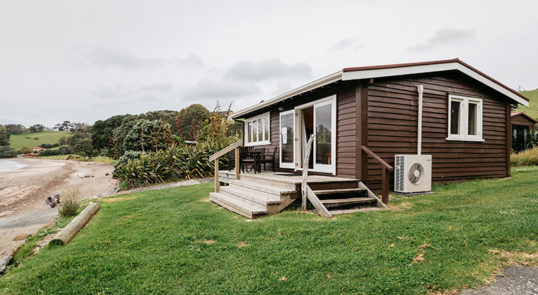 Moonlight Bach - Exterior of the bach looking out over the beach and surrounding area.