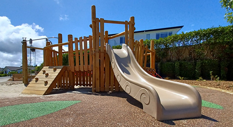 86 Harvest Avenue - Low wooden structure with a climbing wall, raised platform and a low slide.
