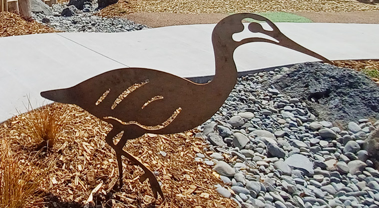 86 Harvest Avenue - A metal heron in one of the small gardens by the path.