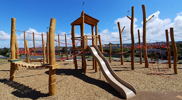 86 Harvest Avenue - Wooden play structure with a wobbly bridge, climbing nets and ropes, and a slide.