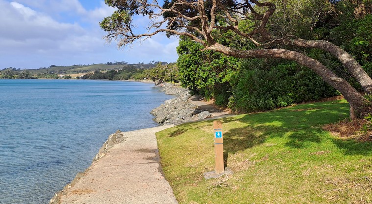 Algies Bay Reserve – Section of footpath along the waterfront with a waymarker post and trees to the right. Photo credit: M Woodside.
