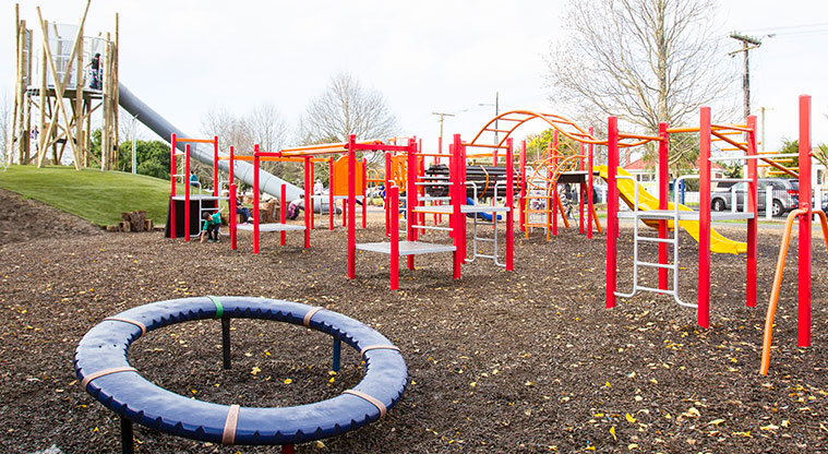 Allenby Park – Brightly coloured playground with a wooden fort and tube slide in the background.