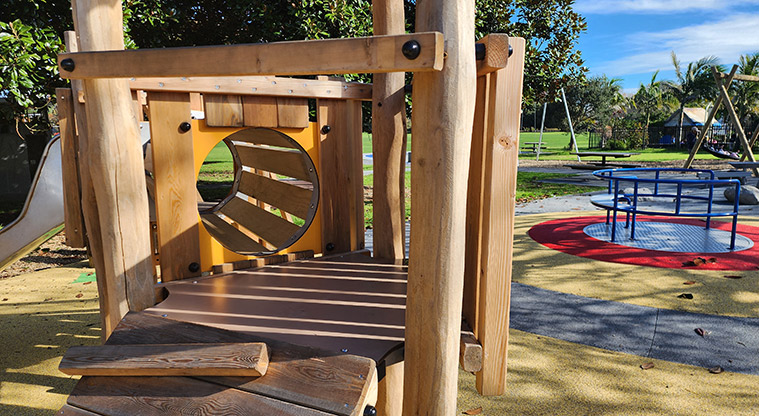 Aorere Park - Looking through the crawl tunnel section of the junior play module with the spinner and other parts of the playground in the background.