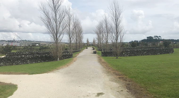 Barry Curtis Park - Wide walking path with stone walls and trees both sides.