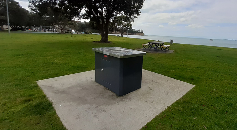 Browns Bay Beach Reserve - Barbecue on a concrete pad with a picnic table and seat nearby. Photo credit: T Hodder.