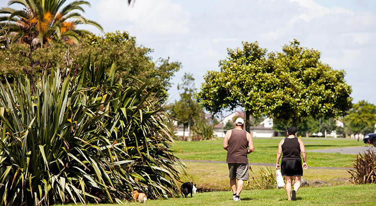 Bruce Pulman Park - Two people walking their dogs through the park. Photo credit: Theo Leach.