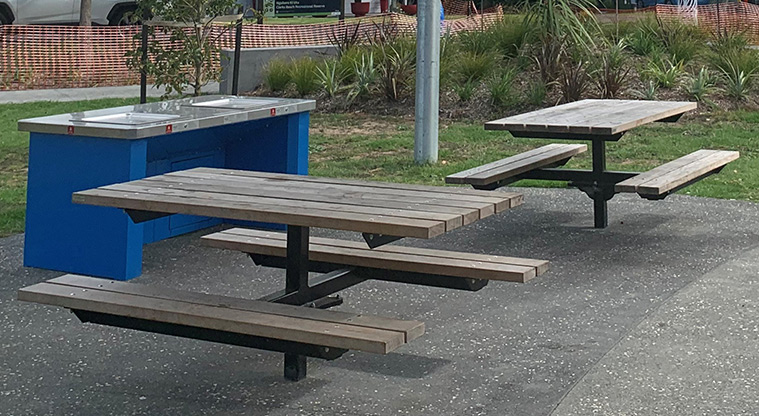 Ngahere Ki Uta / Clarks Beach Recreational Reserve and Golf Club - Barbecue and picnic tables on a concrete surface.