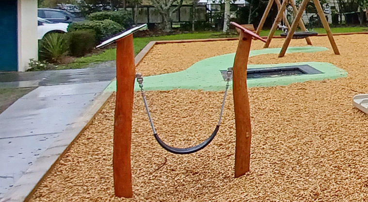 Collins Park - Low sling swing with wooden flowers on top of the posts.