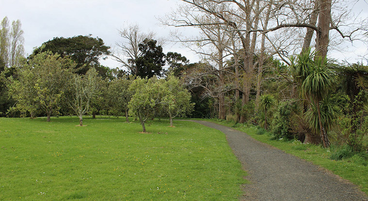 Cranwell Park - Gravel path along the right hand side of the park with open space and trees in the background.