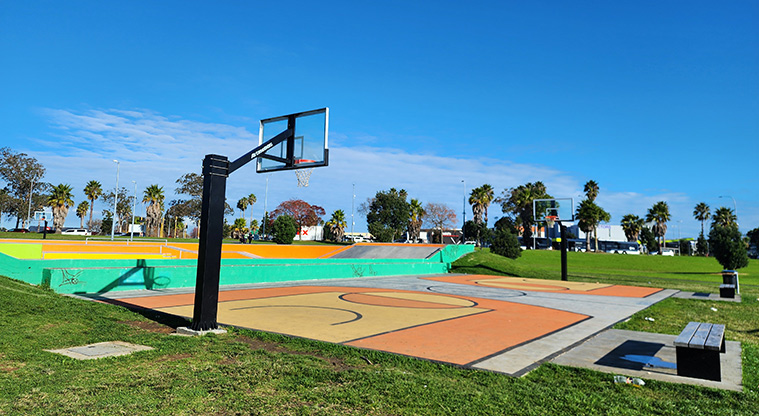 David Lange Park - Brightly coloured basketball court with the skate park and sports field in the background.