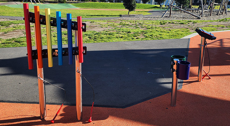 David Lange Park - A series of brightly coloured interactive musical instruments with open grassed space in the background.
