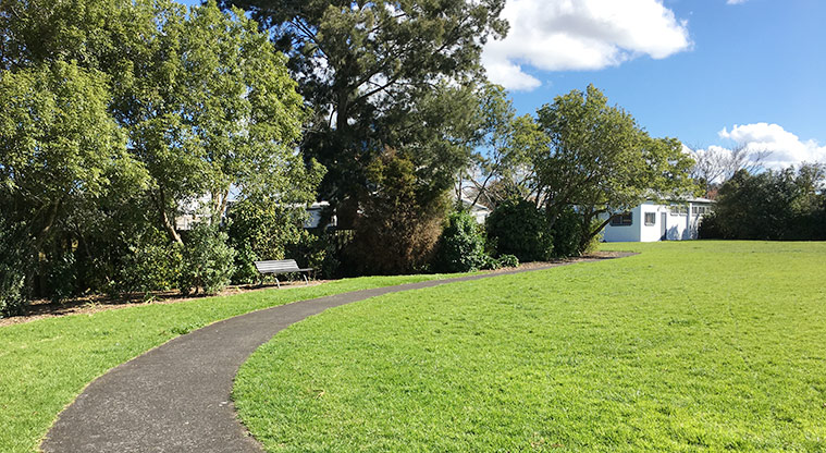 Edendale Reserve - Section of the path around the southern side of the sports field, and a seat under the trees. Photo credit: S Hulse.