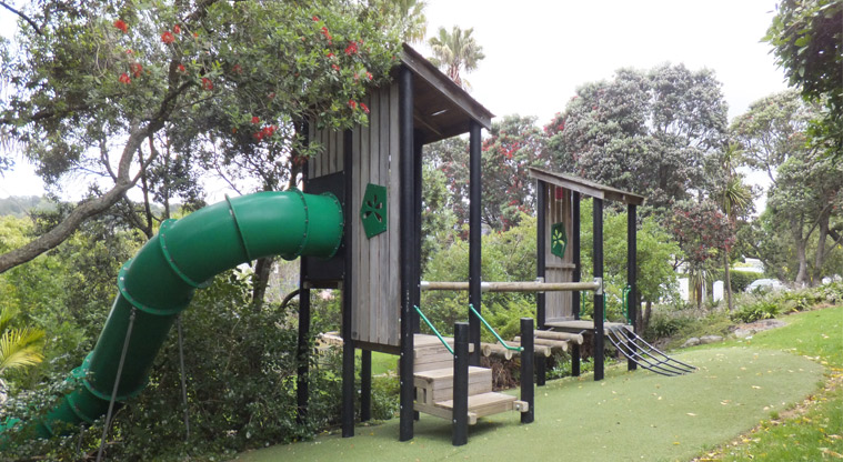 Edenvale Park - Two covered wooden towers with climbing net, wobbly bridge, balance log and steps, and a curved green slide. Photo credit: J Grigg.