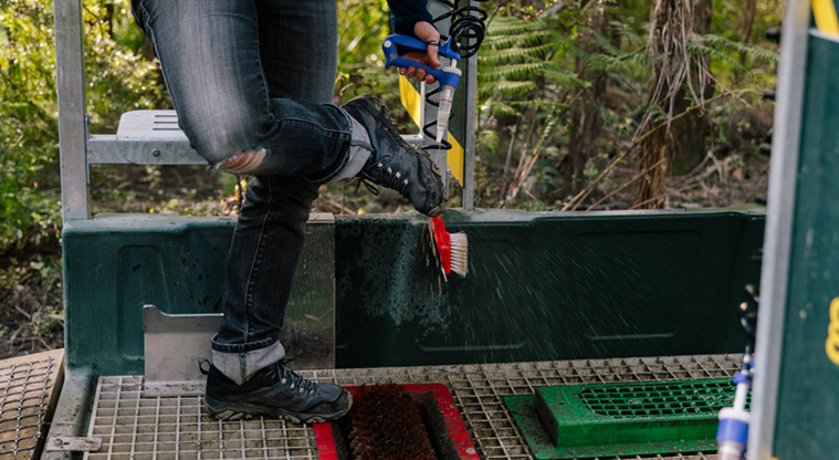 Eskdale Reserve - Person using the spray for cleaning boots before entering, and on leaving the tracks.