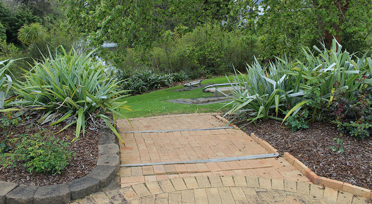 Falls Park - Section of the brick path with gardens and seats overlooking Oratia Stream.