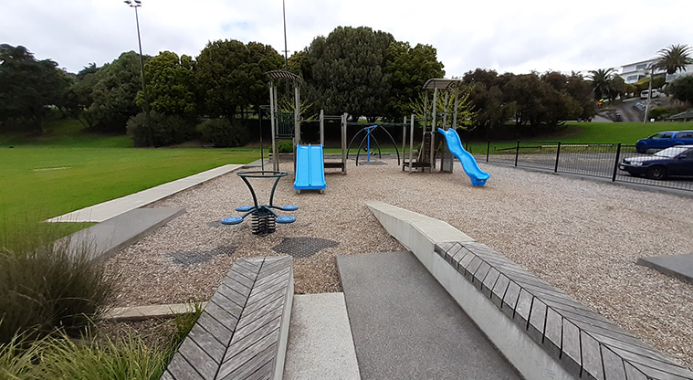 Glover Park - The playground with a section of the fence and car park on the right, and a section of the sports fields on the left.