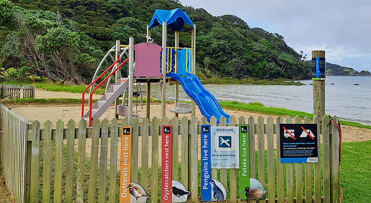 Gooseberry Flat - Play ground with a wooden picket fence surrounding two sides, and signs attached to the fence.