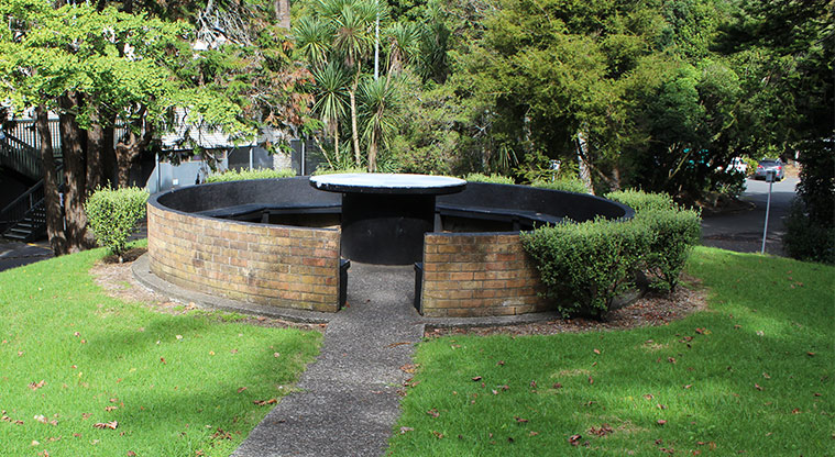 Gribblehirst Park - Round bench seating with table in the center on the side of the park road.
