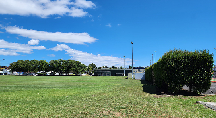 Howick Domain - A section of the sports fields with trees and the toilets in the background.