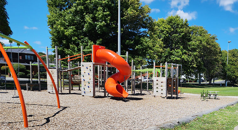 Howick Domain - Part of the playground showing a high covered slide, climbing walls, swings and more.