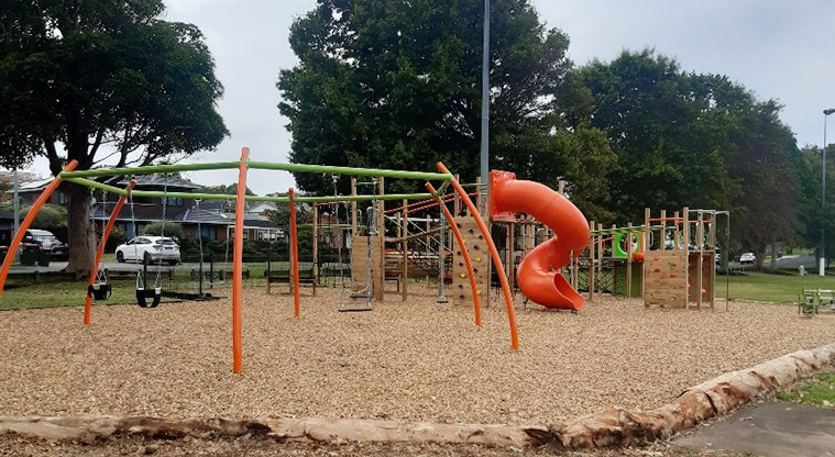 Howick Domain - Set of swings with the rest of the playground in the background.