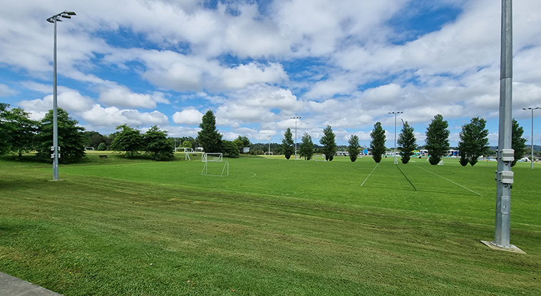 Huapai Recreation Reserve - Section of the sports fields with soccer nets, flood lights and trees.