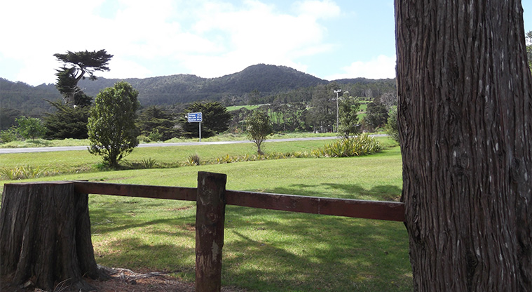 Huia Domain - Open space with Huia Road and hills in the background.