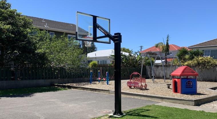 Jean Sampson Reserve - Basketball half-court and the small playground with swings and equipment for small children.