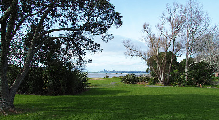 Kelvin Strand - Open green space and trees with a view across the water to Auckland city. Photo credit: Tracey Hodder.