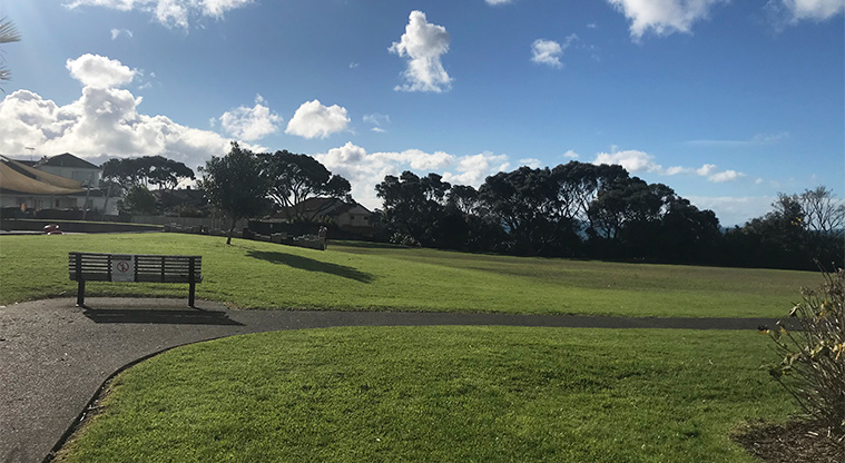 Kennedy Park - Open space with a bench seat on the edge of the path.