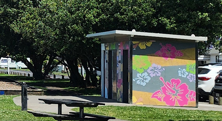 Kiwi Esplanade - Toilet block with a colourful hibiscus mural on the wall.