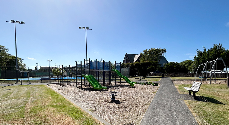 Kupe Reserve - The whole playground with a play module, swings and rocker toy with the tennis courts in the background. Photo credit: S Hulse.