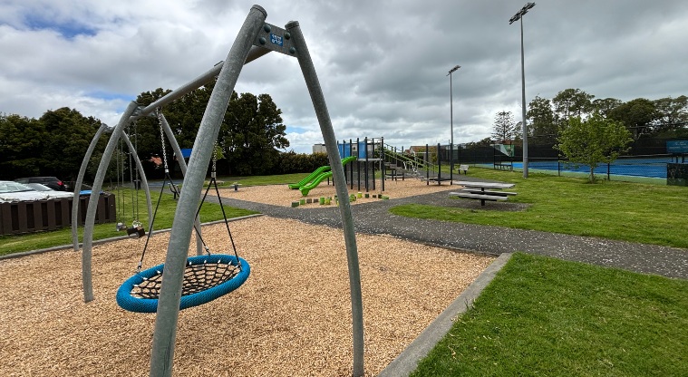 Kupe Reserve - Swings over bark area, picnic table, flat path and slides in the background.