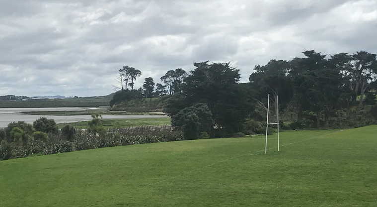 Laurie Gibbons Memorial Park - Section of one of the sports fields with a set of rugby posts, and trees in the background.