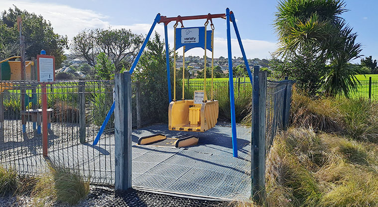 Lloyd Elsmore Park - Mobility swing for wheelchair users inside a small fenced area within the playground. Photo credit: S Hulse.