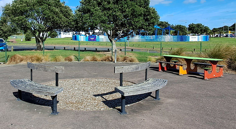 Lloyd Elsmore Park - Colourful tables and bench seats inside the playground area. Photo credit: S Hulse.