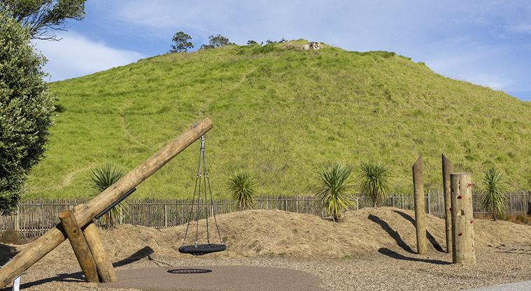 Te Pane o Mataoho / Te Ara Pueru / Māngere Mountain - Stand-alone accessible swing with the side of the maunga in the background.