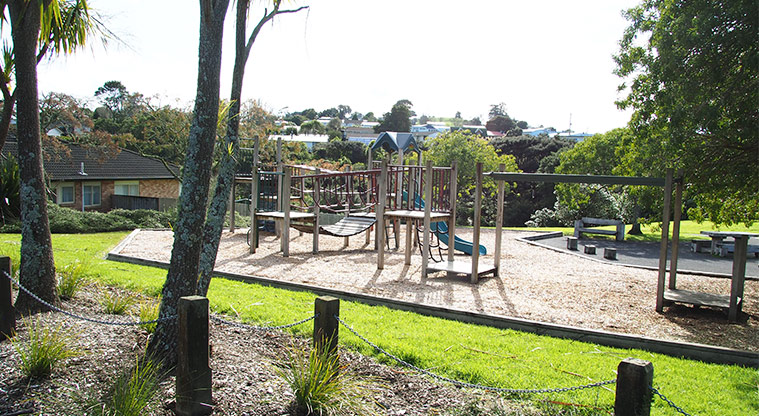 Mānutewhau / Manutewhau Reserve - Playground with bollards, chains and trees in the foreground. Photo credit: Tracey Hodder.